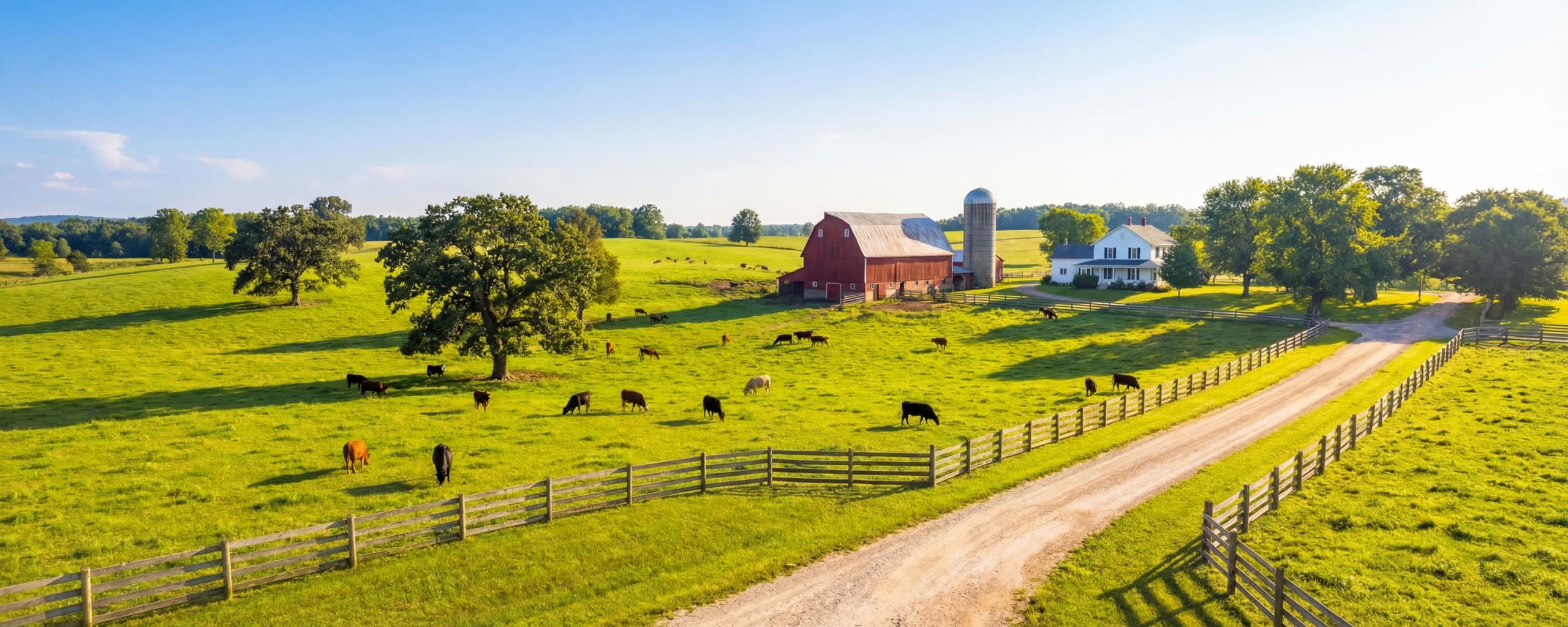 A family farm with fenced pasture and a red barn